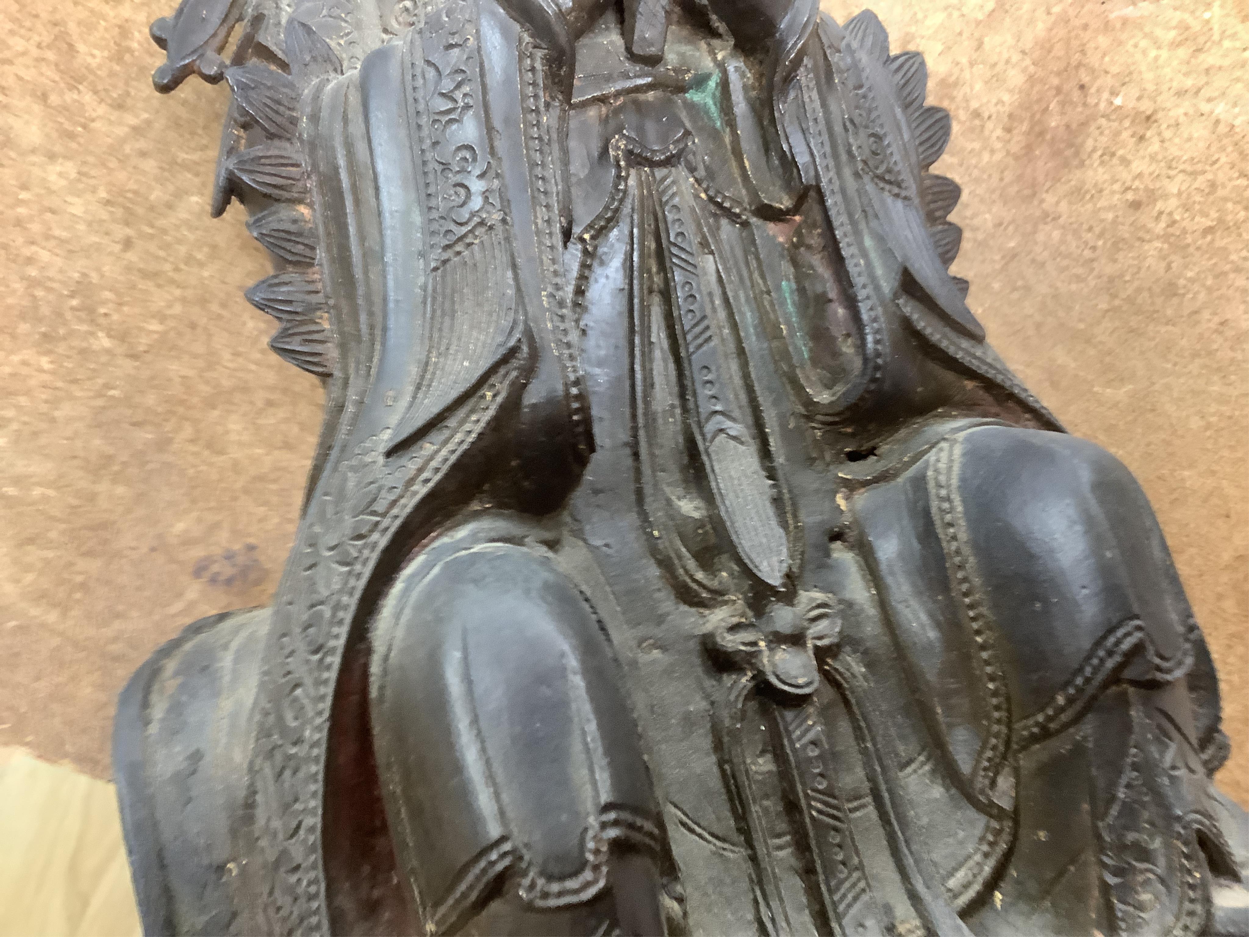 A Chinese late Ming bronze seated figure of Xi Wangmu, early 17th century (on stand). 34.5cm high not including stand.